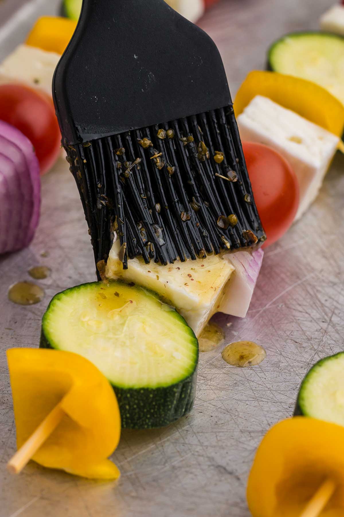 Brushing the veg and cheese skewers with marinade