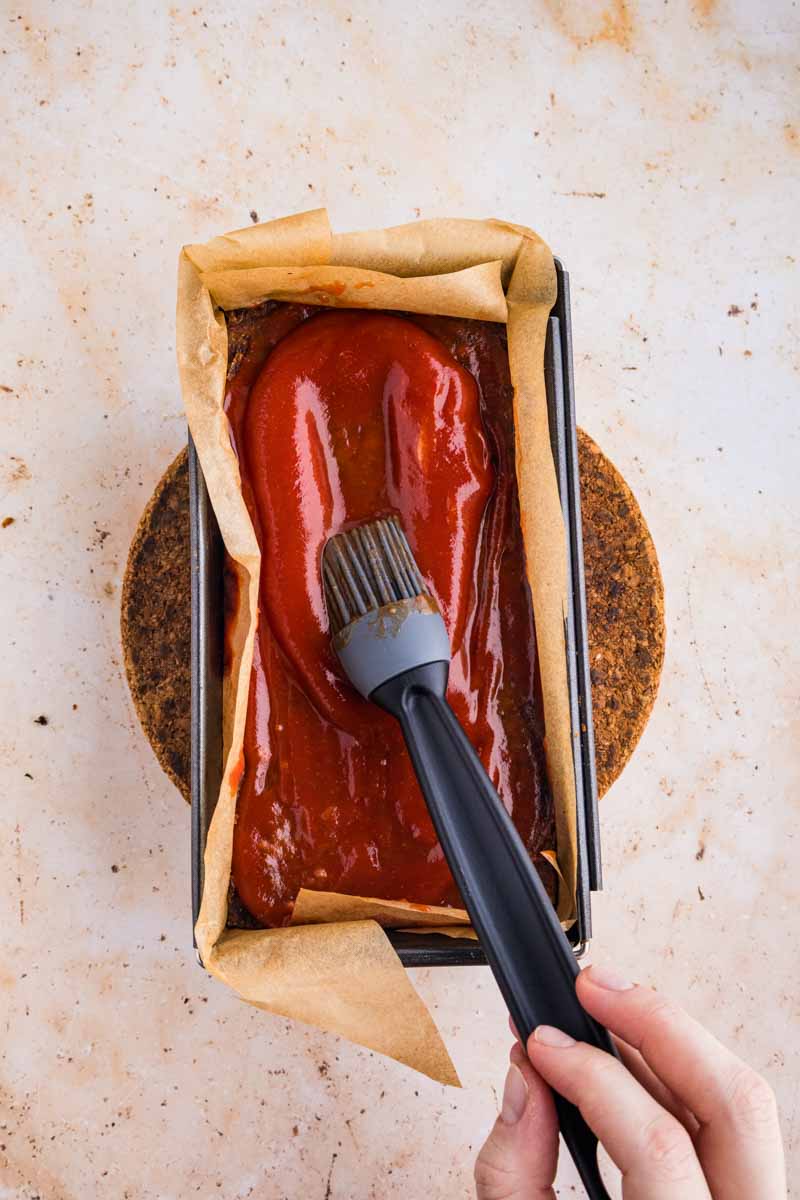 brushing ketchup on Vegetarian Meatloaf