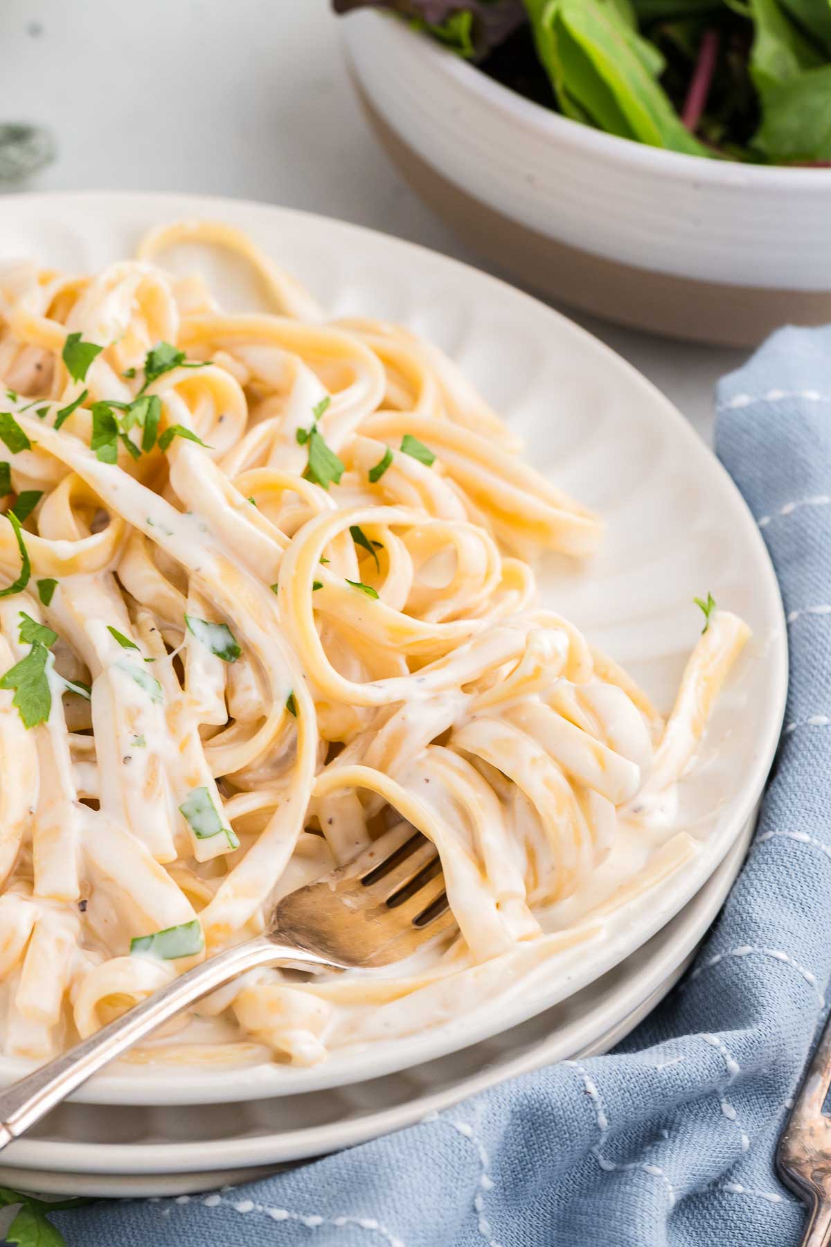 a white bowl full of cream cheese pasta