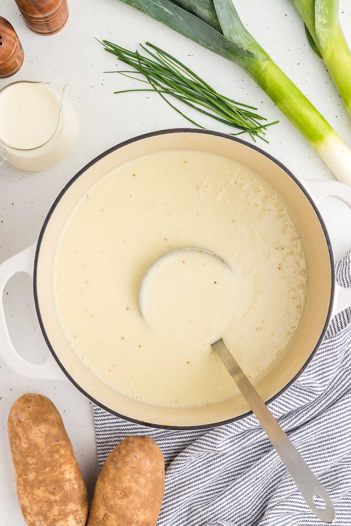 pot of potato leek soup with a ladle scooping out a serving