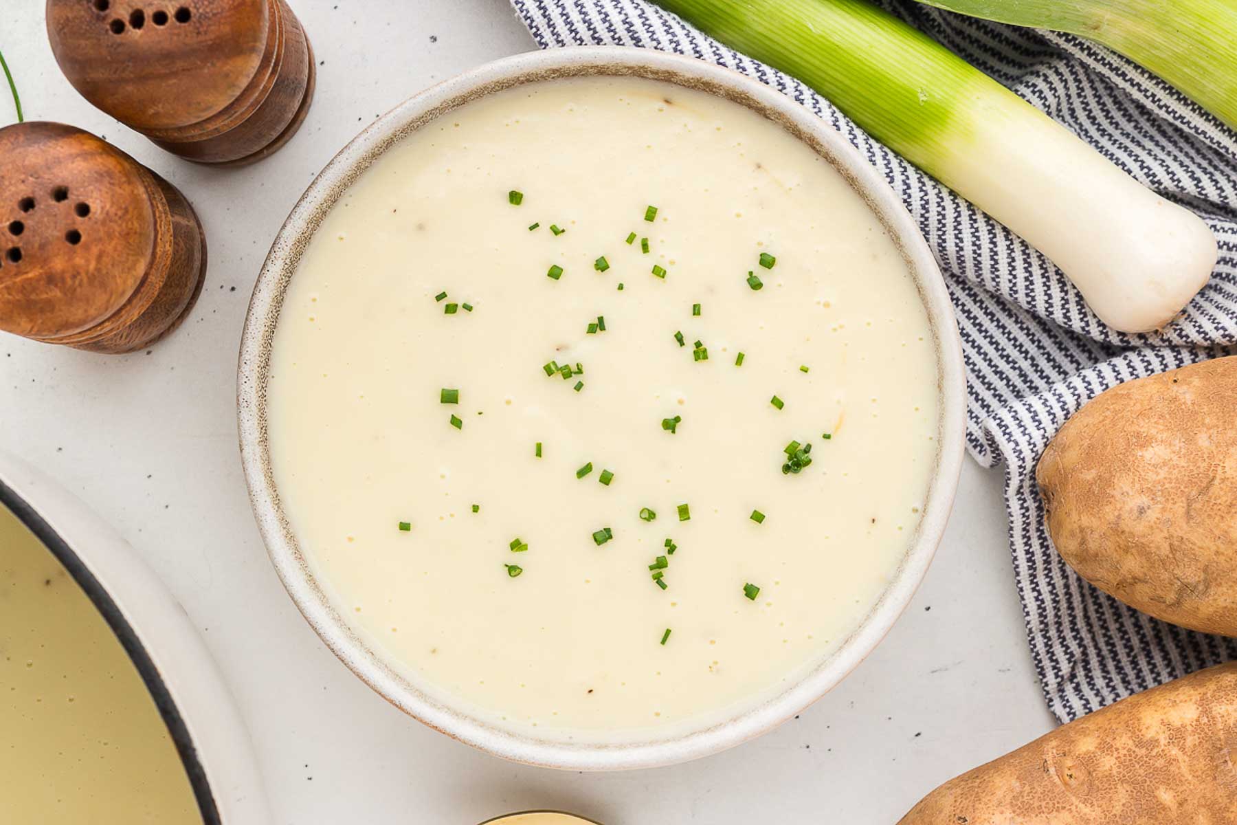 top view of a bowl of potato leek soup with chive garnish