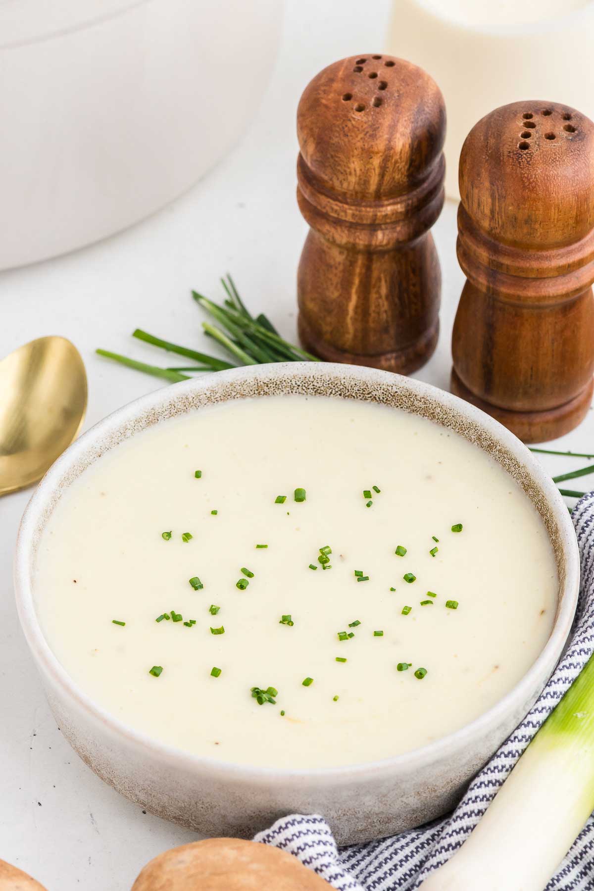 bowl of potato leek soup with wooden salt and pepper shakers