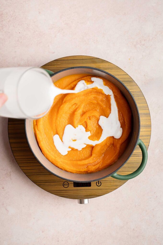 adding coconut milk to butternut squash soup