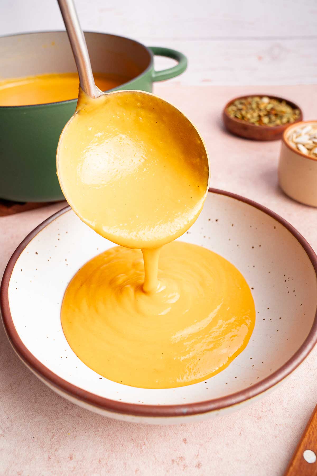 butternut squash soup being ladled into a bowl