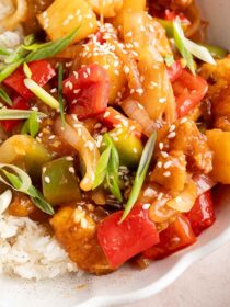 close up of sweet and sour tofu and rice in a white bowl